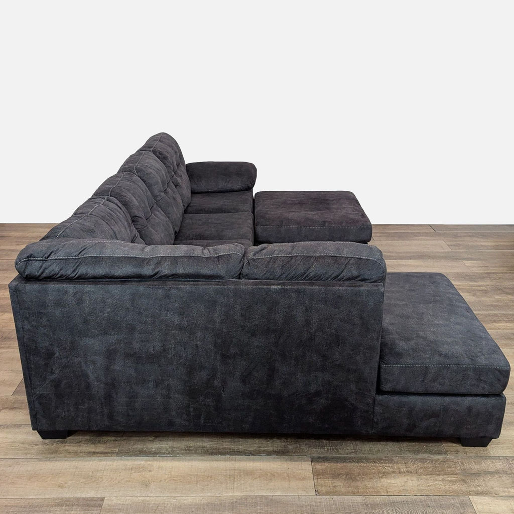 Side view of a spacious gray sectional featuring plush cushions and matching ottoman.
