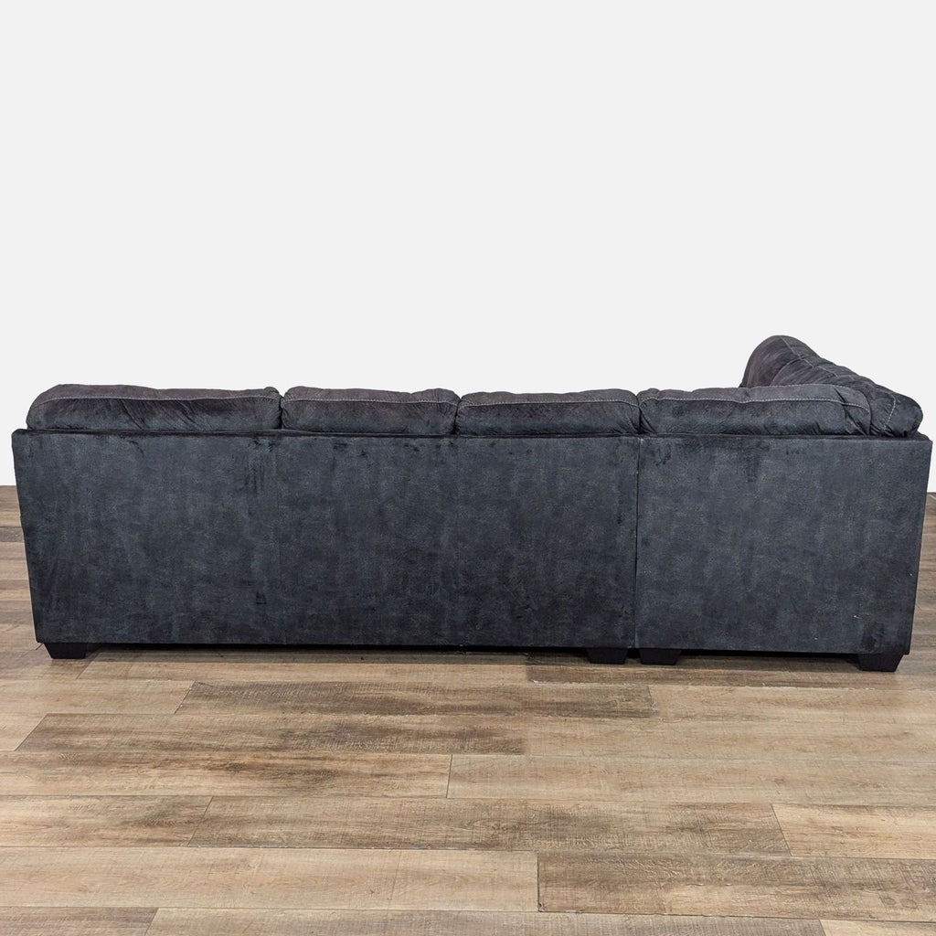 Back view of a large gray sectional sofa with textured fabric and cozy design.