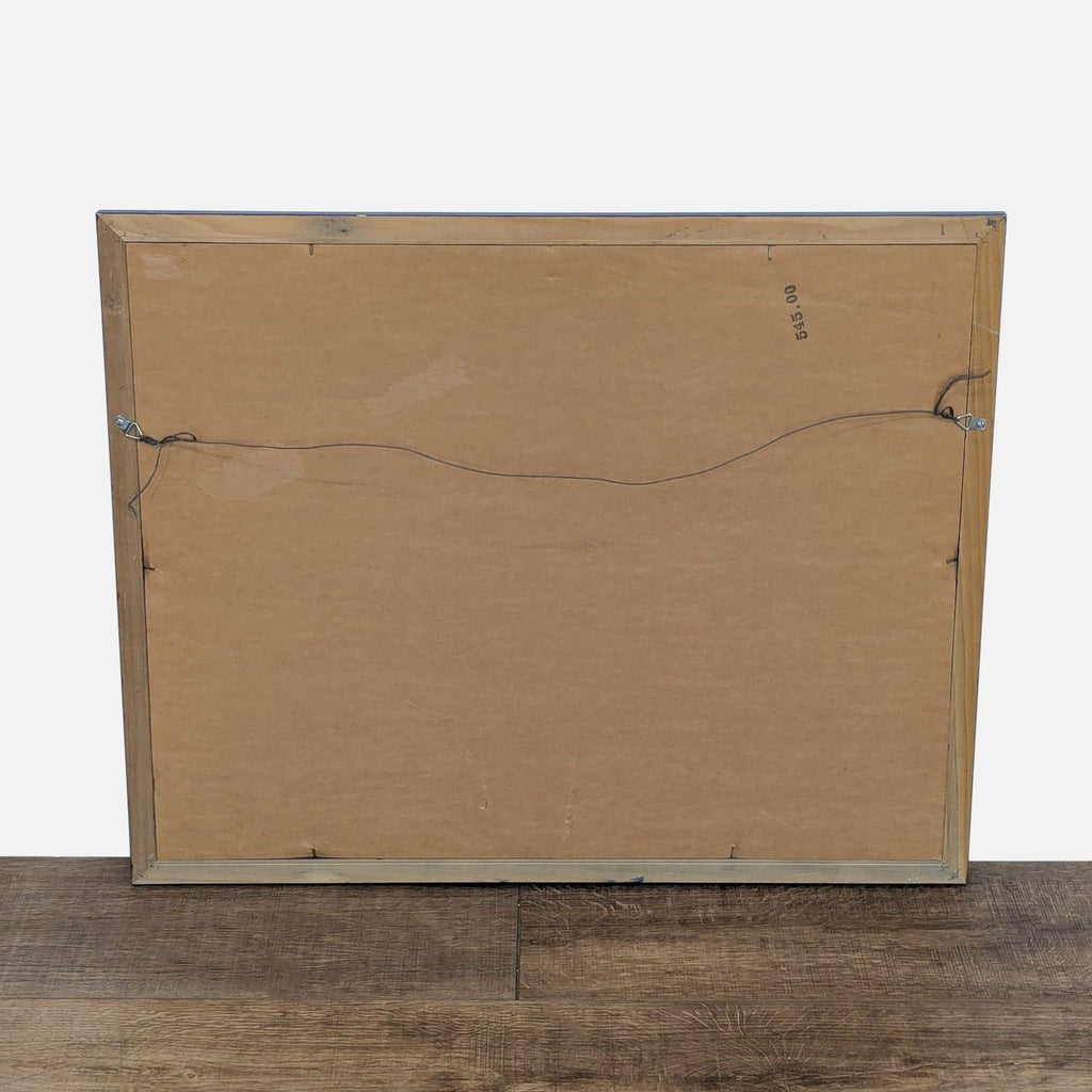 Back of a framed print showing wire for hanging; simple cardboard backing.