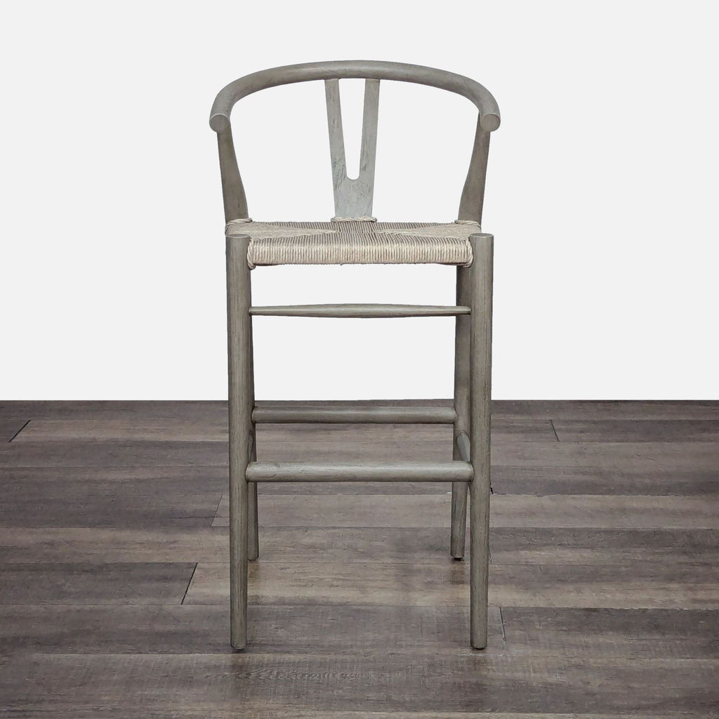 Mid-century style teak stool by Lulu & Georgia with a woven seat and a back cutout design.