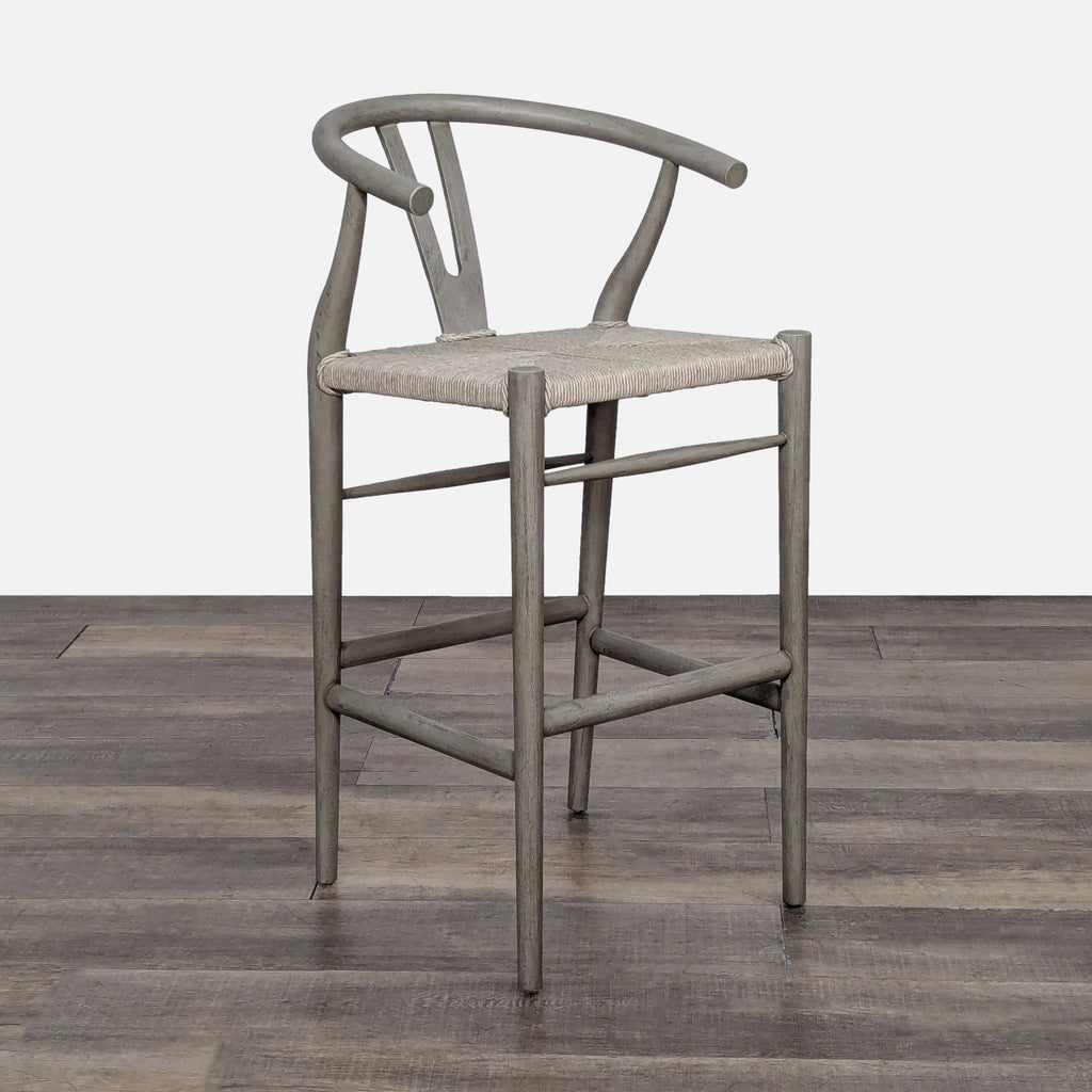 Lulu & Georgia teak stool featuring a woven seat and a distinct cutout back, inspired by mid-century style.
