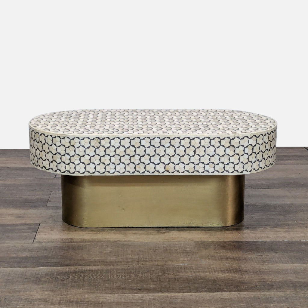 Oval coffee table with a brass base and geometric bone inlay top.