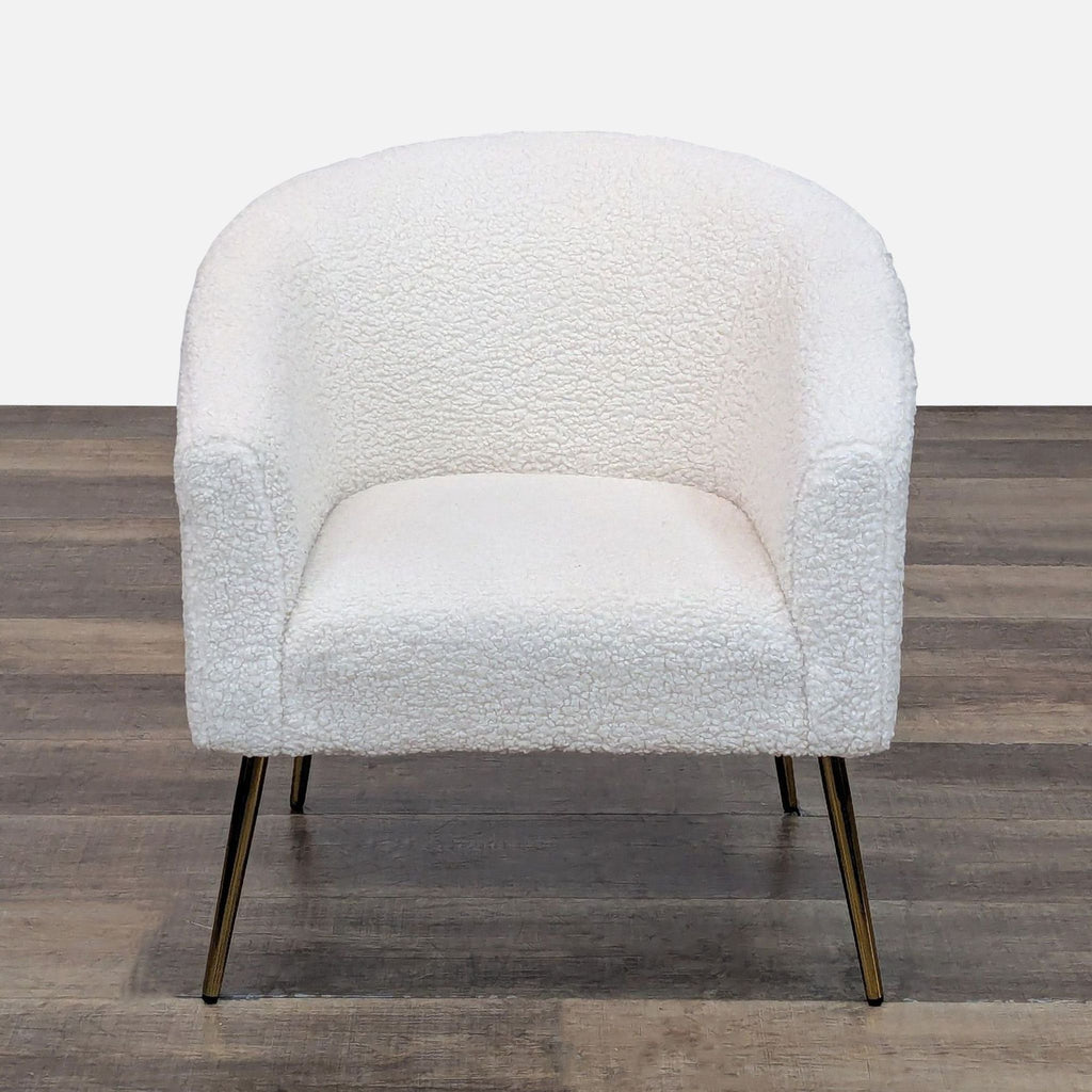 Front view of barrel armchair in boucle with gold metal legs.