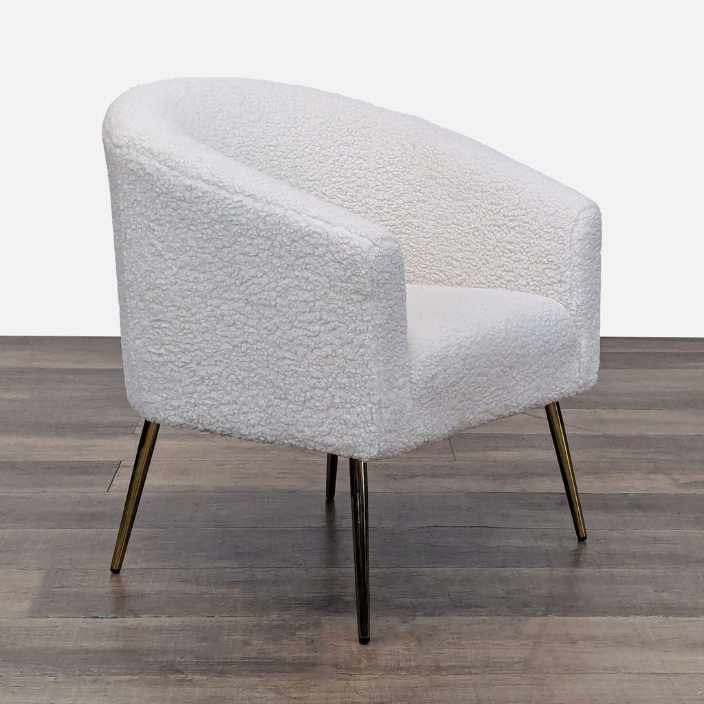 Angled view of barrel chair with boucle fabric and metal legs.
