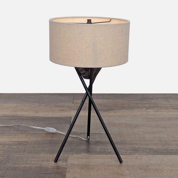 Tripod lamp with light diffuser and linen drum shade.