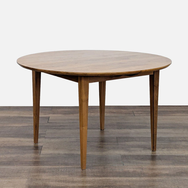 Round walnut dining table with tapered legs from Room & Board.