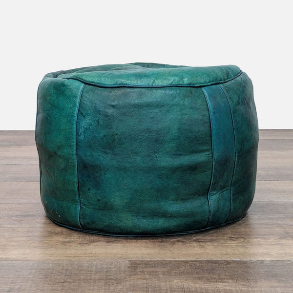 Green leather ottoman from Reperch on wooden floor.