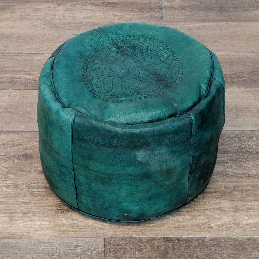 Round green ottoman with embossed top design by Reperch.