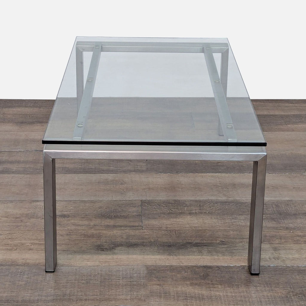 Room & Board glass coffee table with sturdy metal legs and minimalist design.