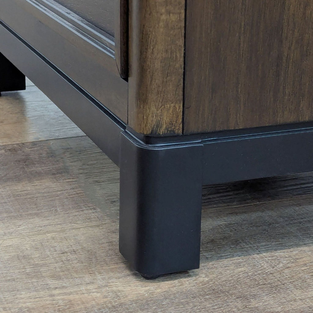 Close-up of nightstand leg detail on wooden floor.
