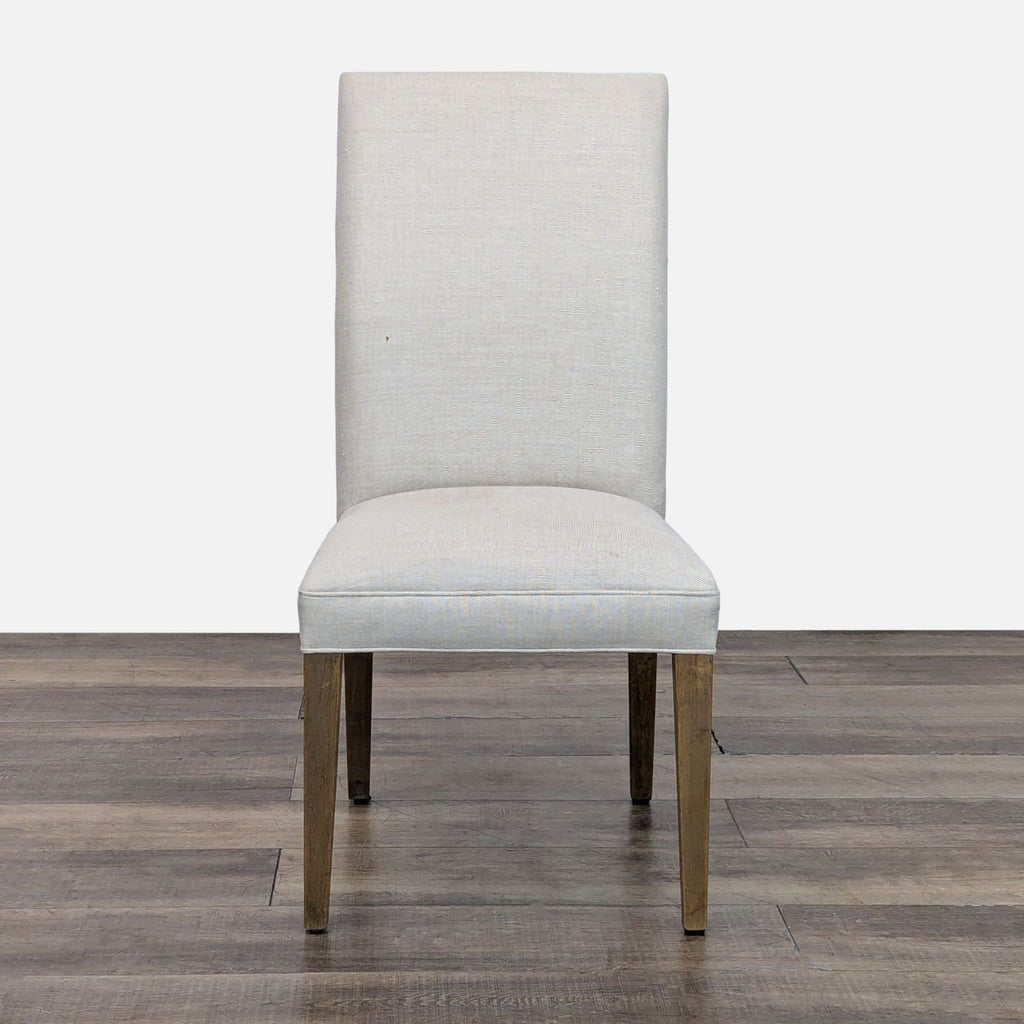 Front view of a dining chair with weathered oak legs and linen upholstery.  