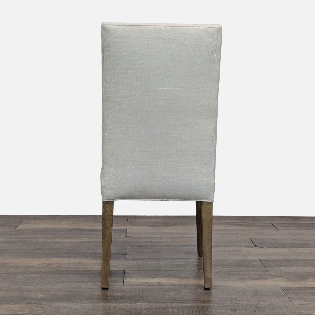 Back view of a high-back dining chair with smooth upholstery and oak legs.