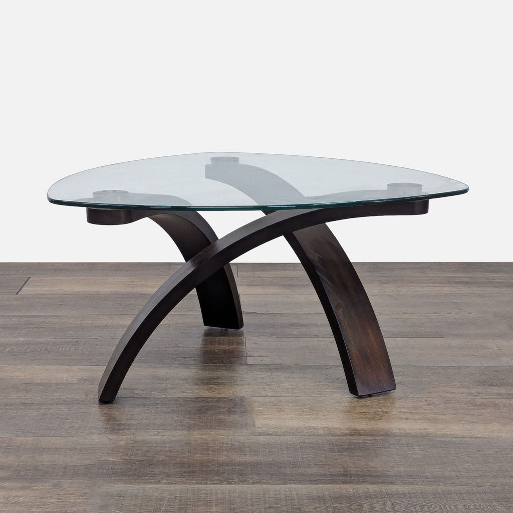 Triangular glass coffee table with a hardwood base by Reperch.