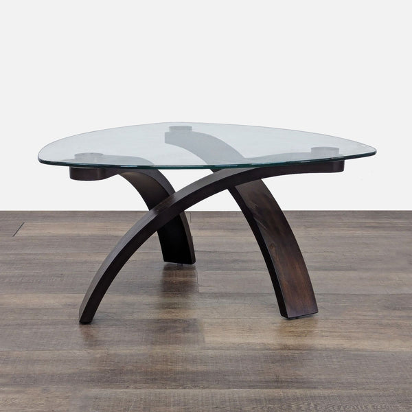 Triangular glass coffee table with a hardwood base by Reperch.