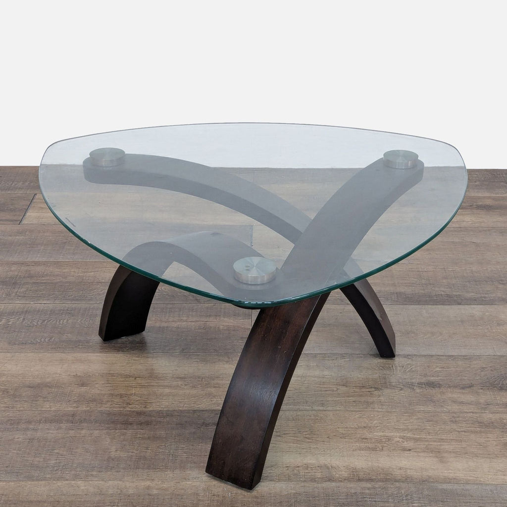 Stylish coffee table by Reperch with a triangular glass surface and wooden legs.
