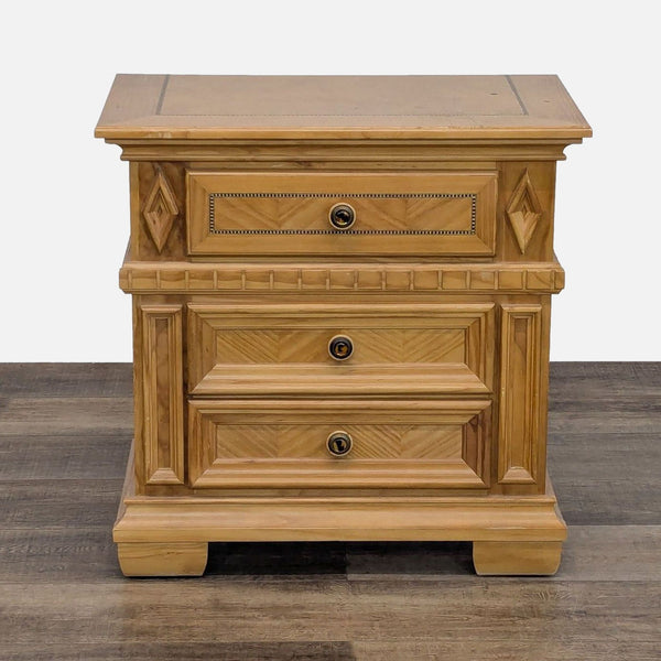 Reperch end table with intricate wood carvings and three closed drawers.