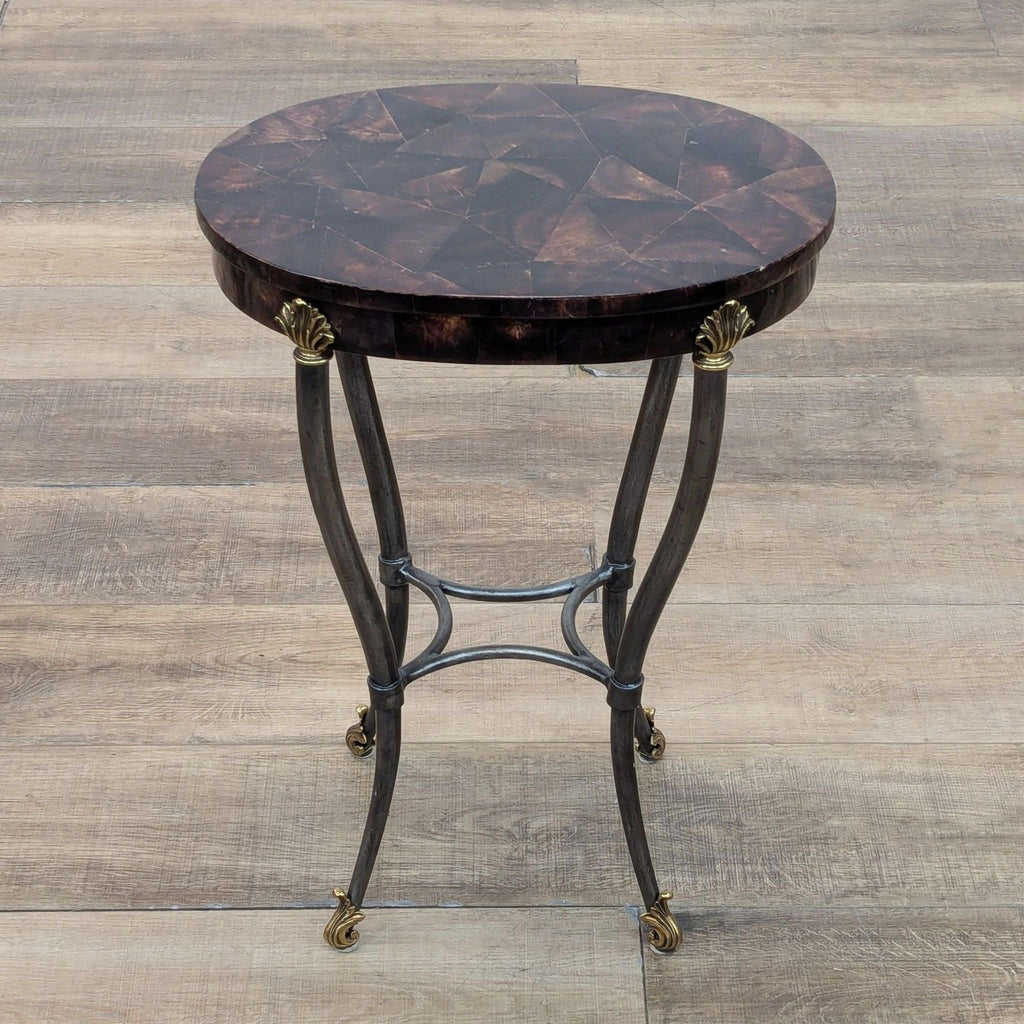 Round occasional table in Hollywood Regency style with faux tortoise shell top and metal shell accents.