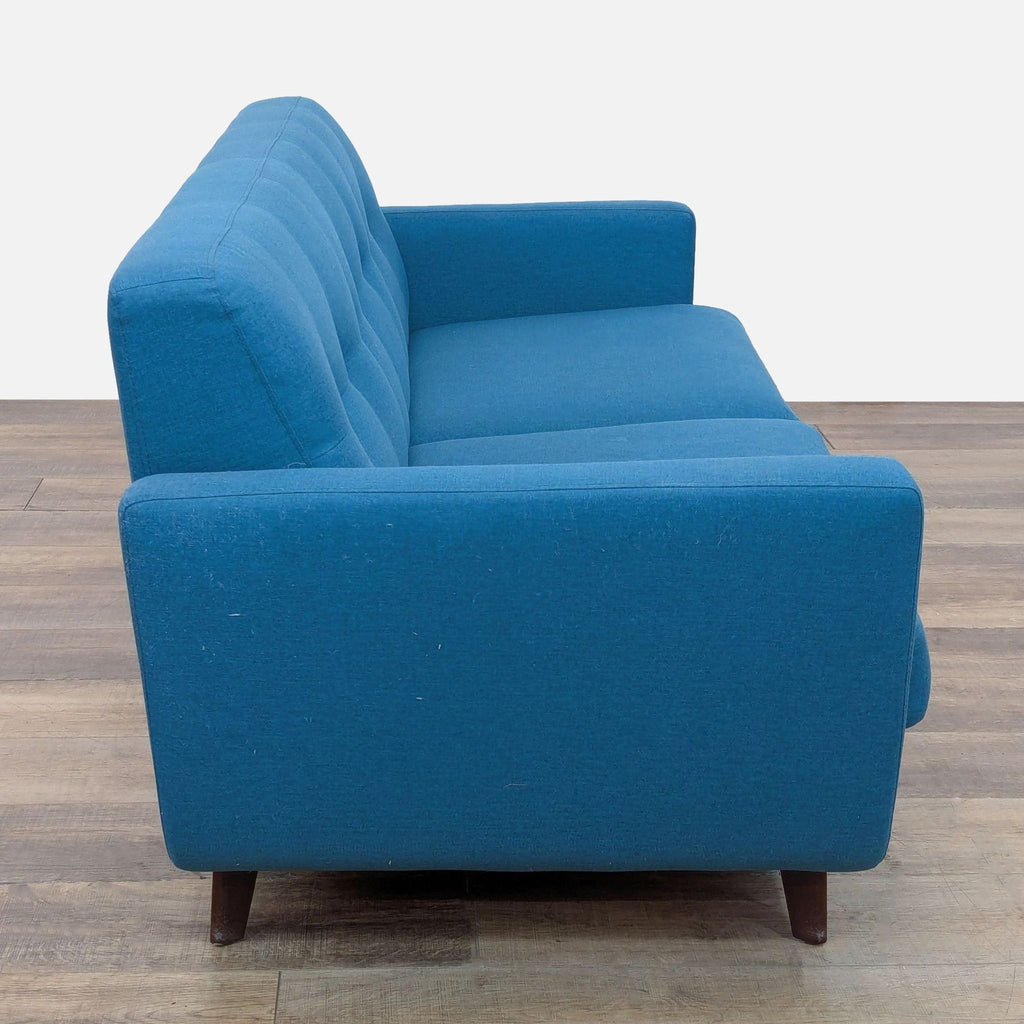 Side view of a blue loveseat, showcasing its sleek, modern design.