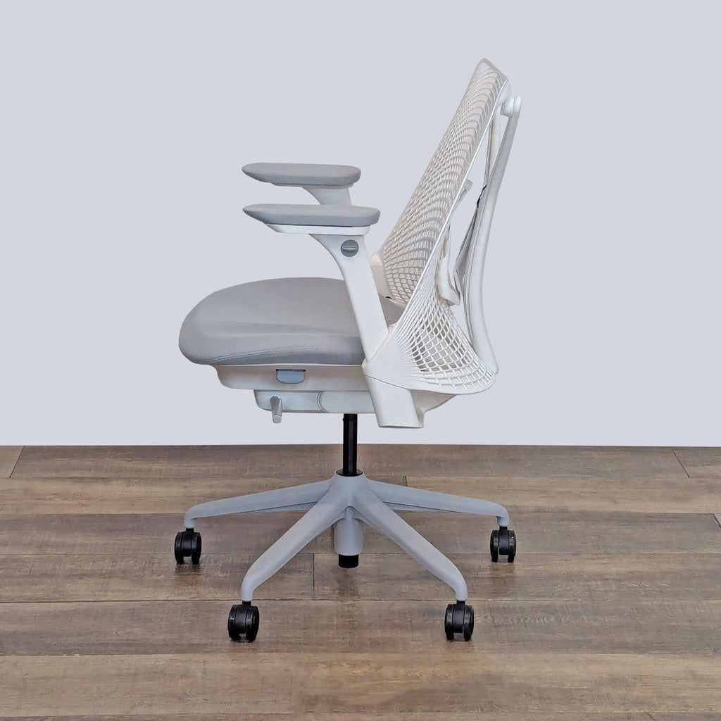 Side view of a Herman Miller chair featuring adjustable armrests and a ventilated back design.