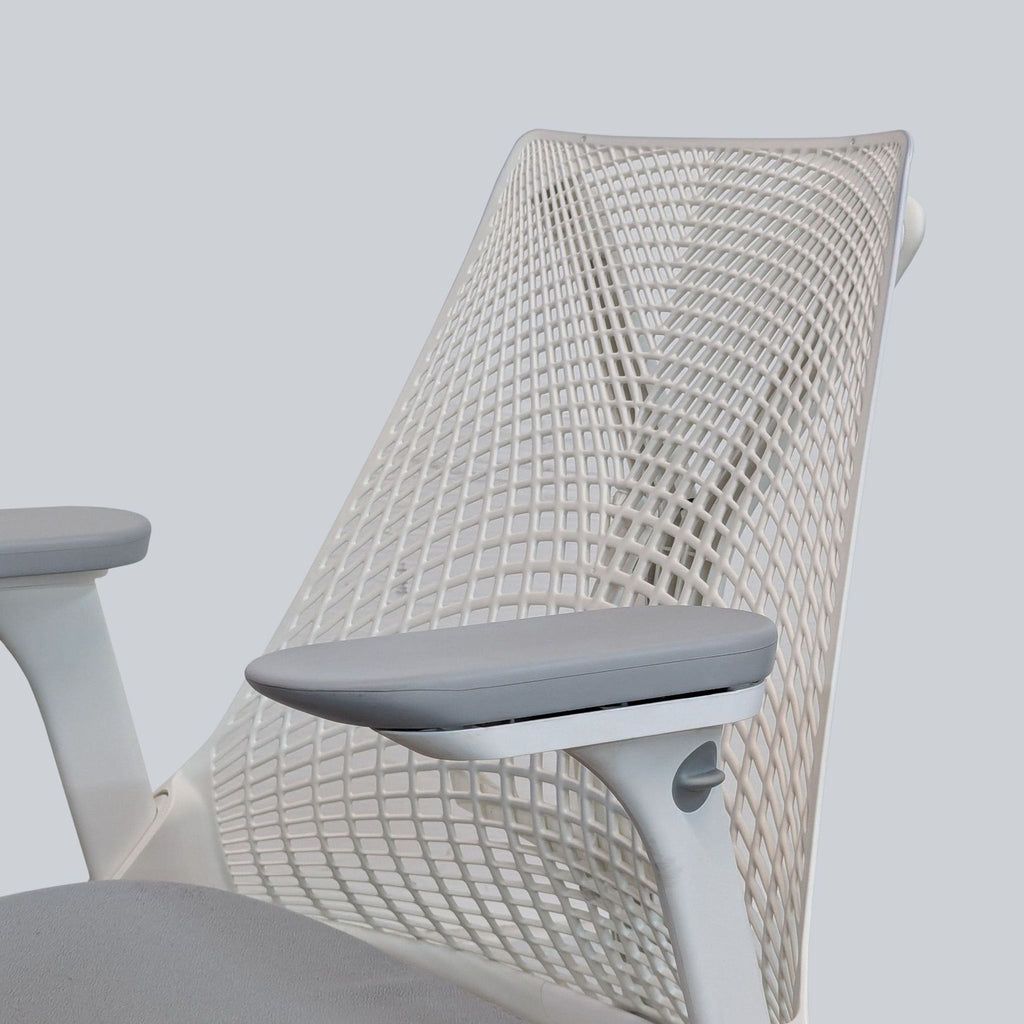 Close-up of Herman Miller chair showing the ventilated backrest and ergonomic arm padding.