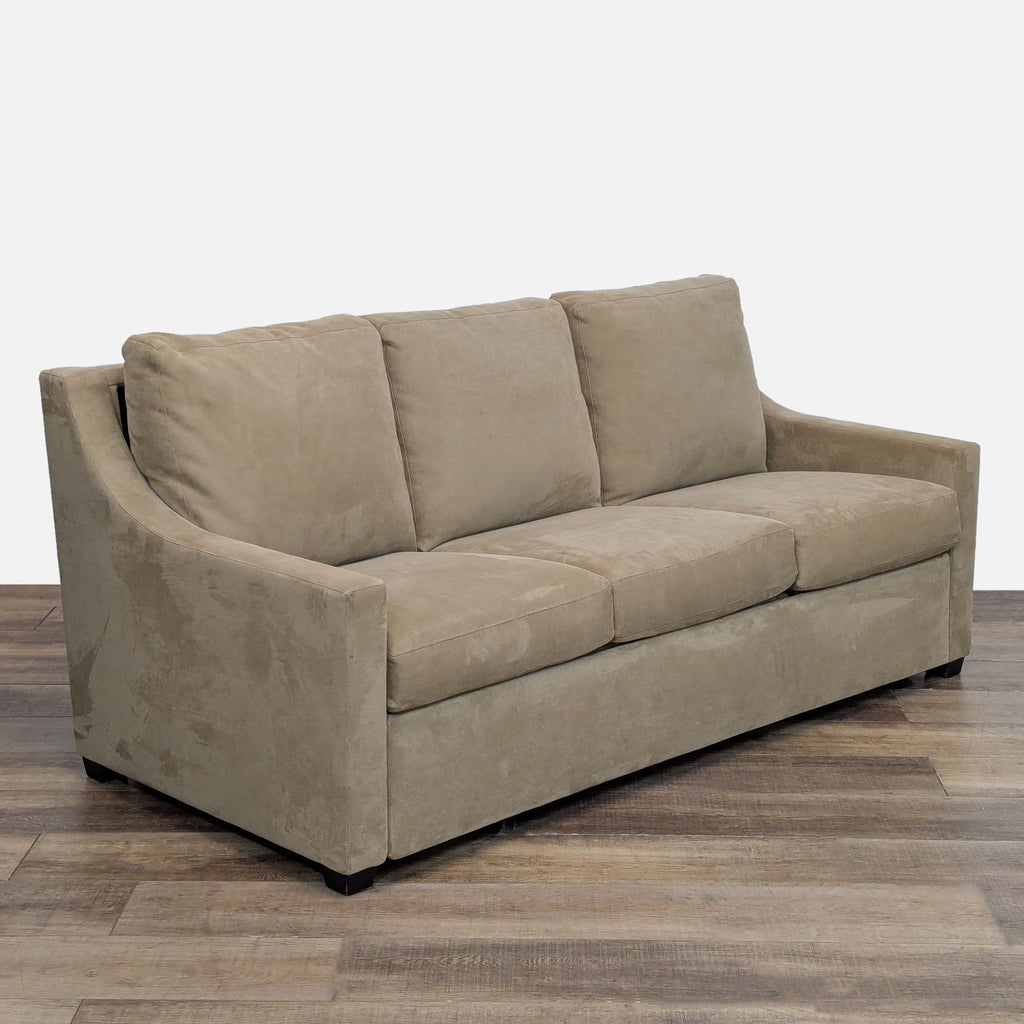 Angled view of a Crate and Barrel convertible sleeper sofa with plush cushions.
