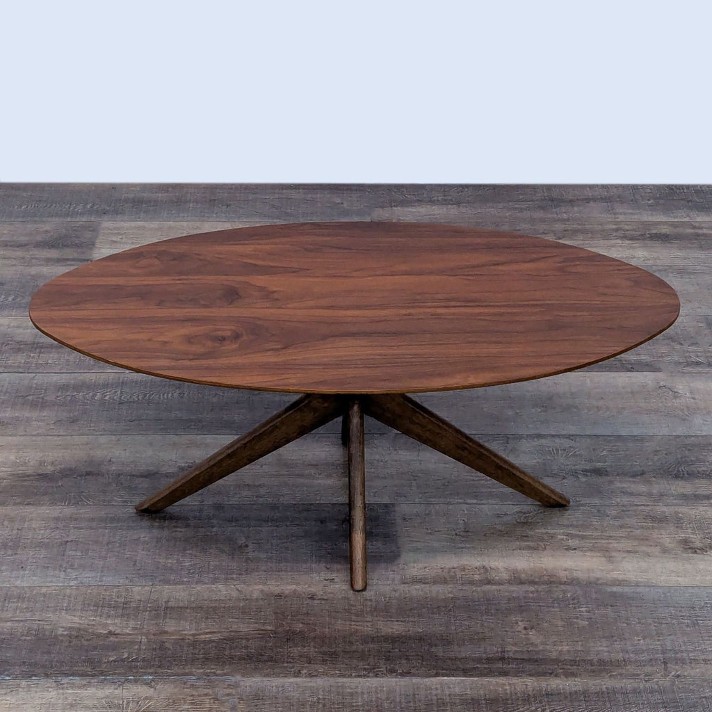 Contemporary round coffee table in walnut veneer with a stylish crossed-leg base.