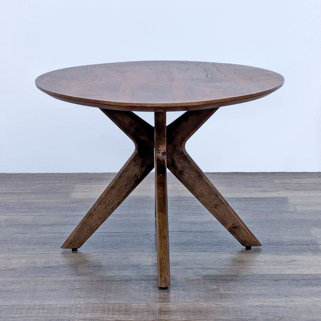 Elegant walnut finish coffee table featuring a round top and unique base design.