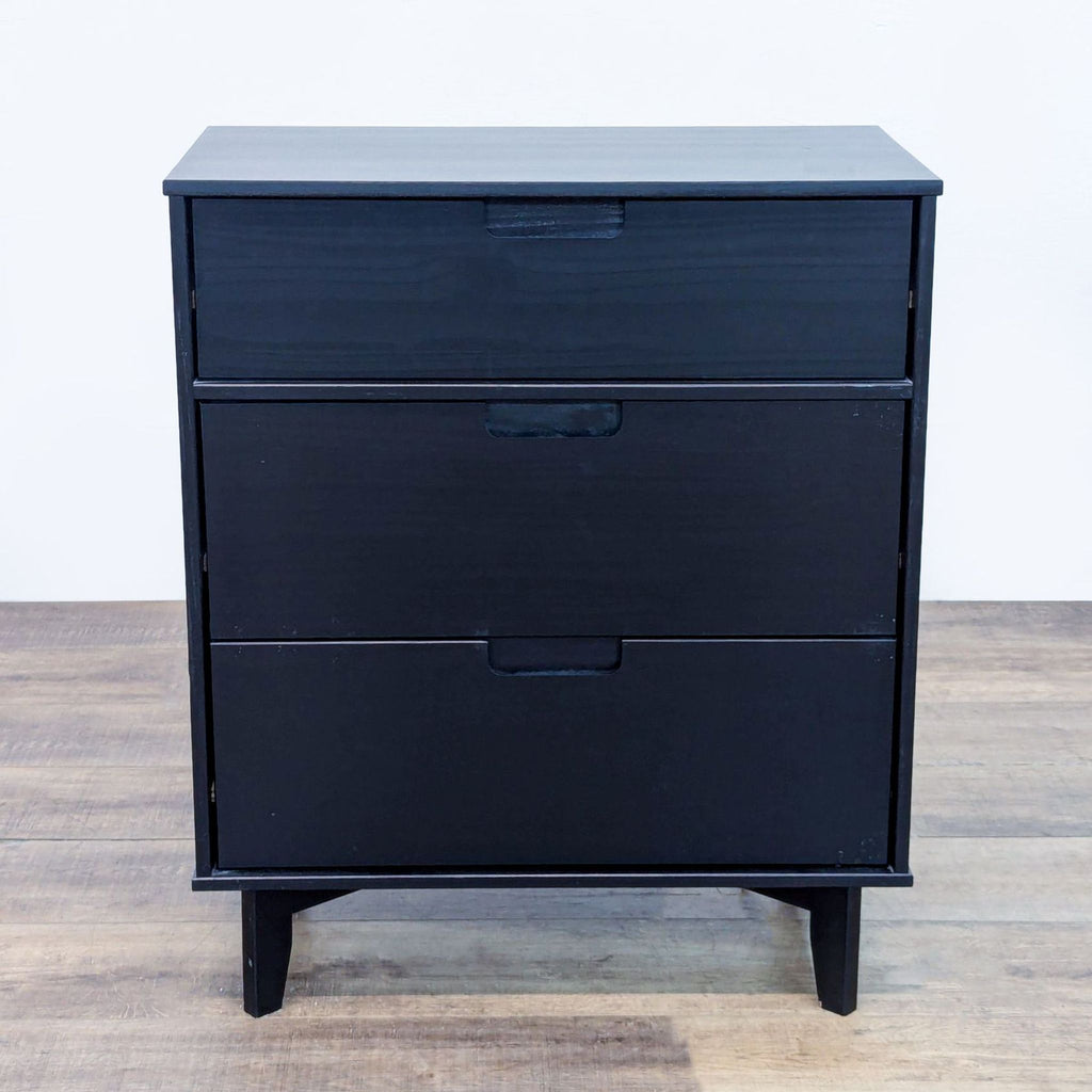 Black wood dresser with angled legs and cutout handles, viewed from the front.