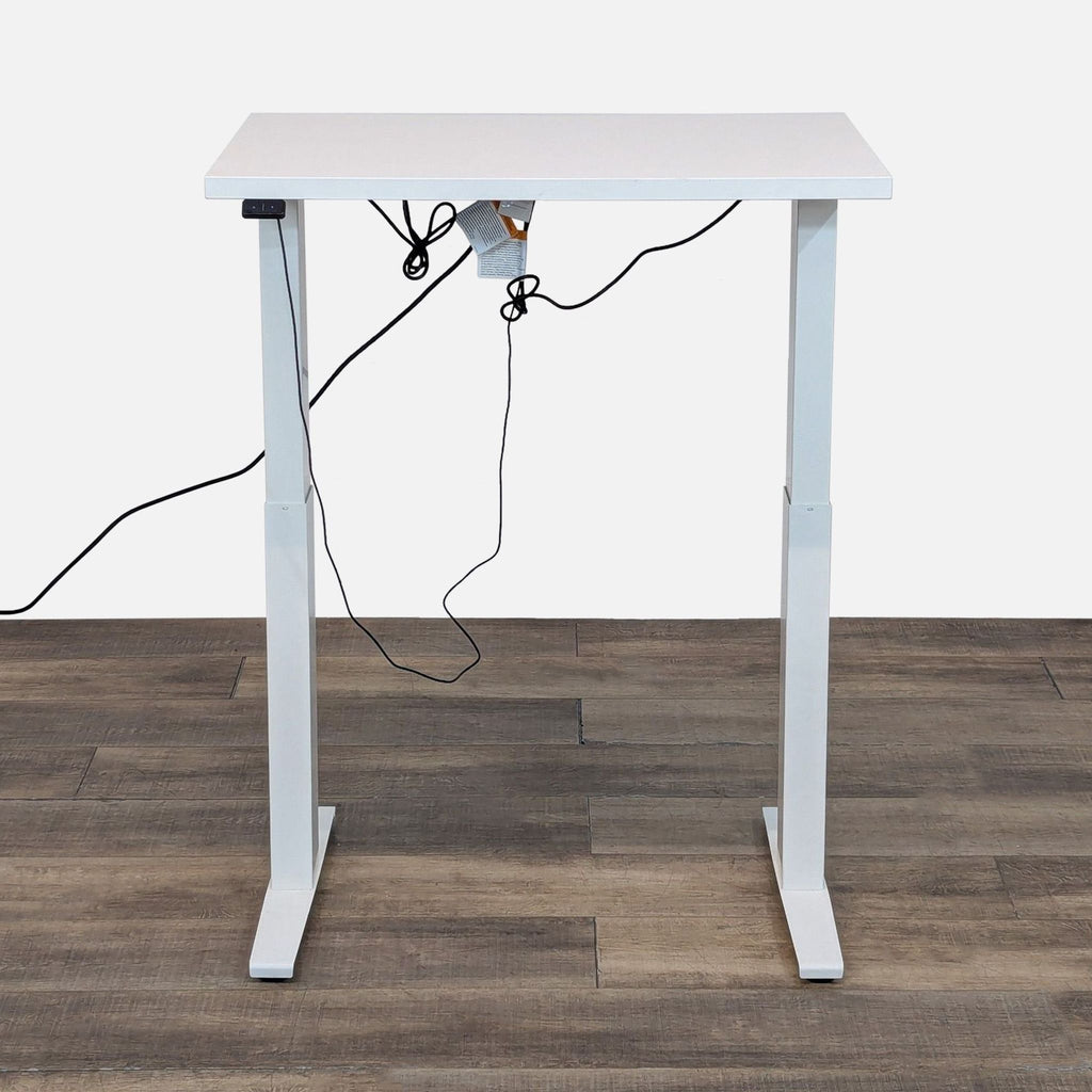 Height-adjustable white desk, steel base, with visible power cord.