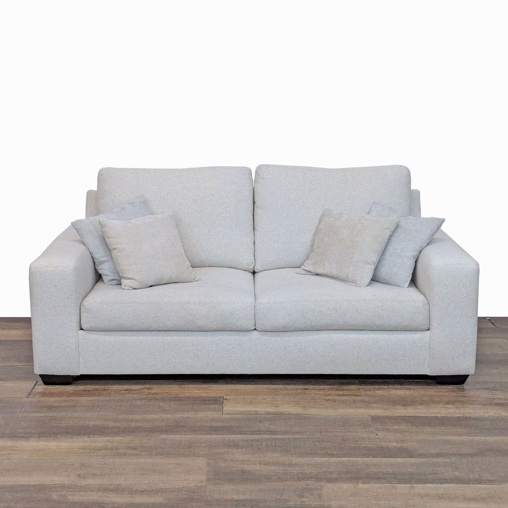 Front view of Pottery Barn loveseat with square arms and plush cushions.