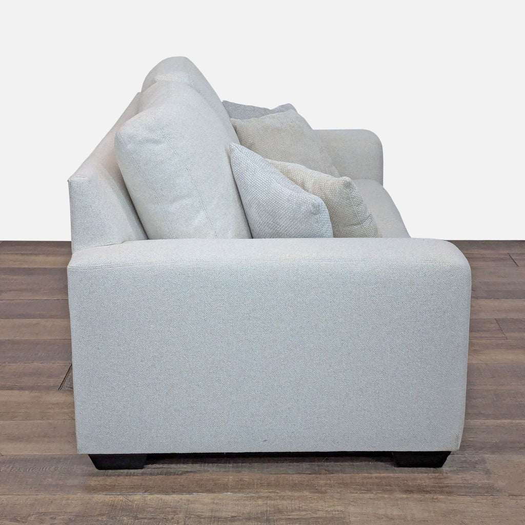 Side view of Pottery Barn loveseat, showing square arms and soft cushions.