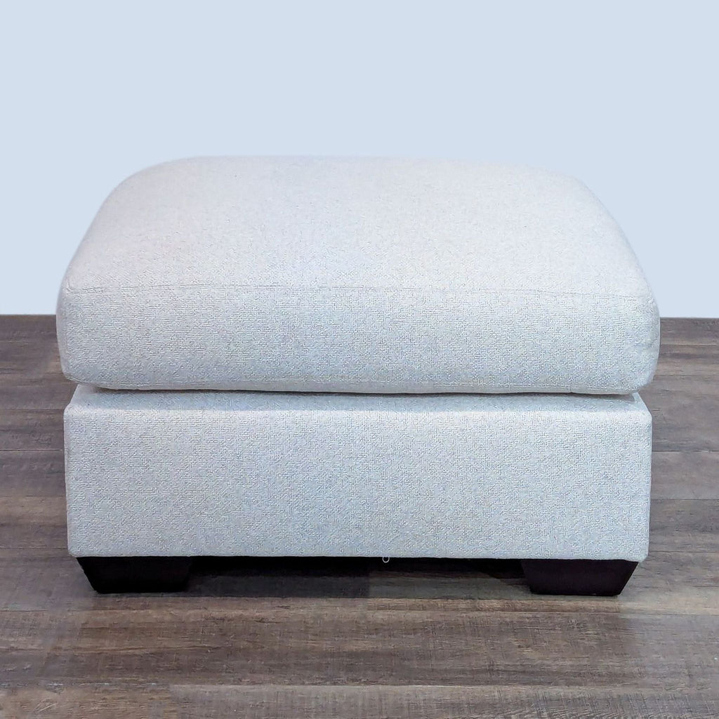 Stylish square ottoman with rubberwood base and soft fabric cushion.