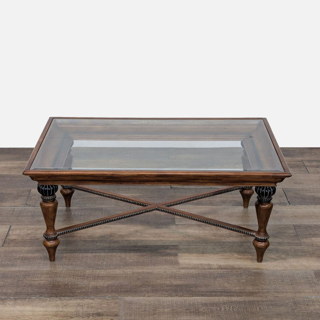 Stylish coffee table by Macy's. Features carved wood frame with bead accents and glass top.