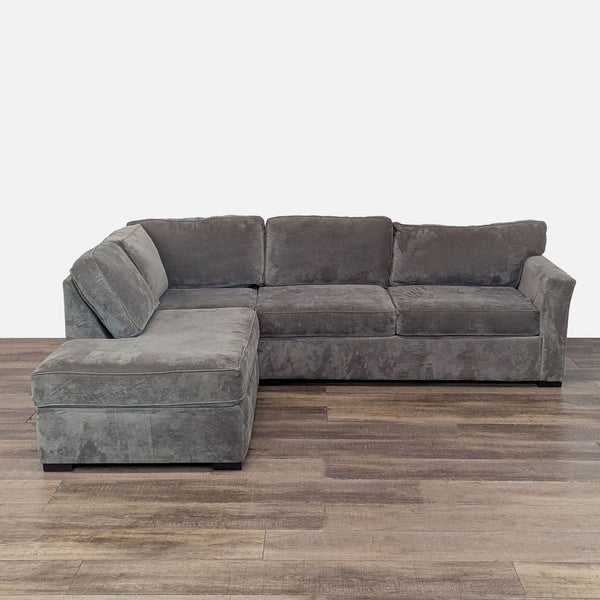 Gray sectional sofa with chaise on wood floor.