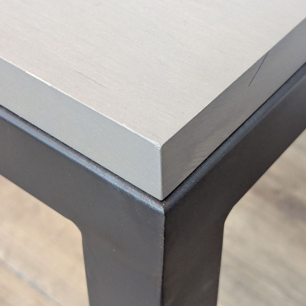 Close-up of the maple top and steel base on a side table.