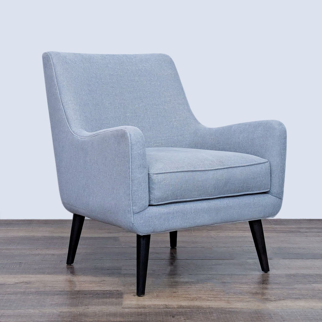 Angled view of blue mid-century chair by Room and Board.