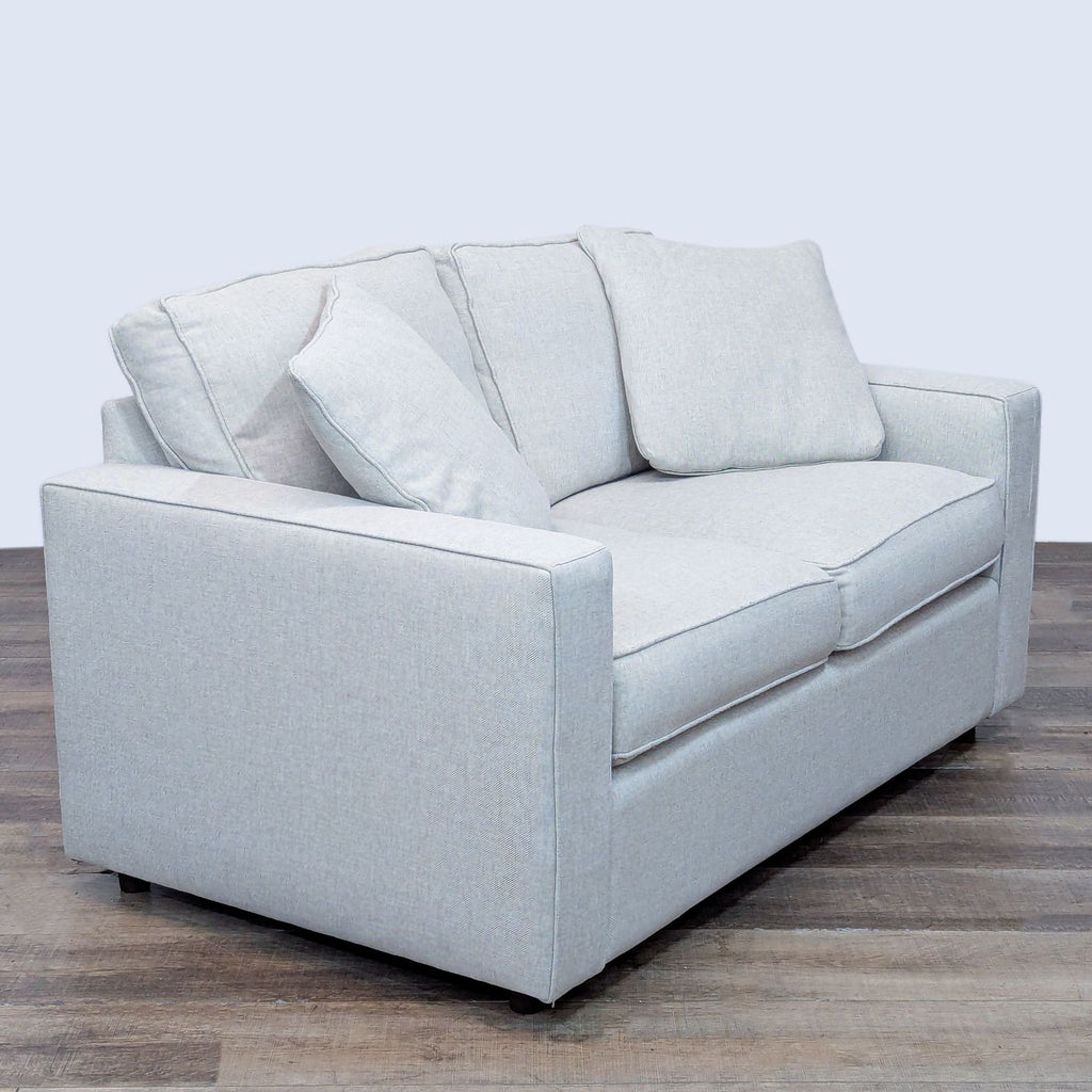 Comfortable loveseat with sink-in cushions, upholstered in light linen.