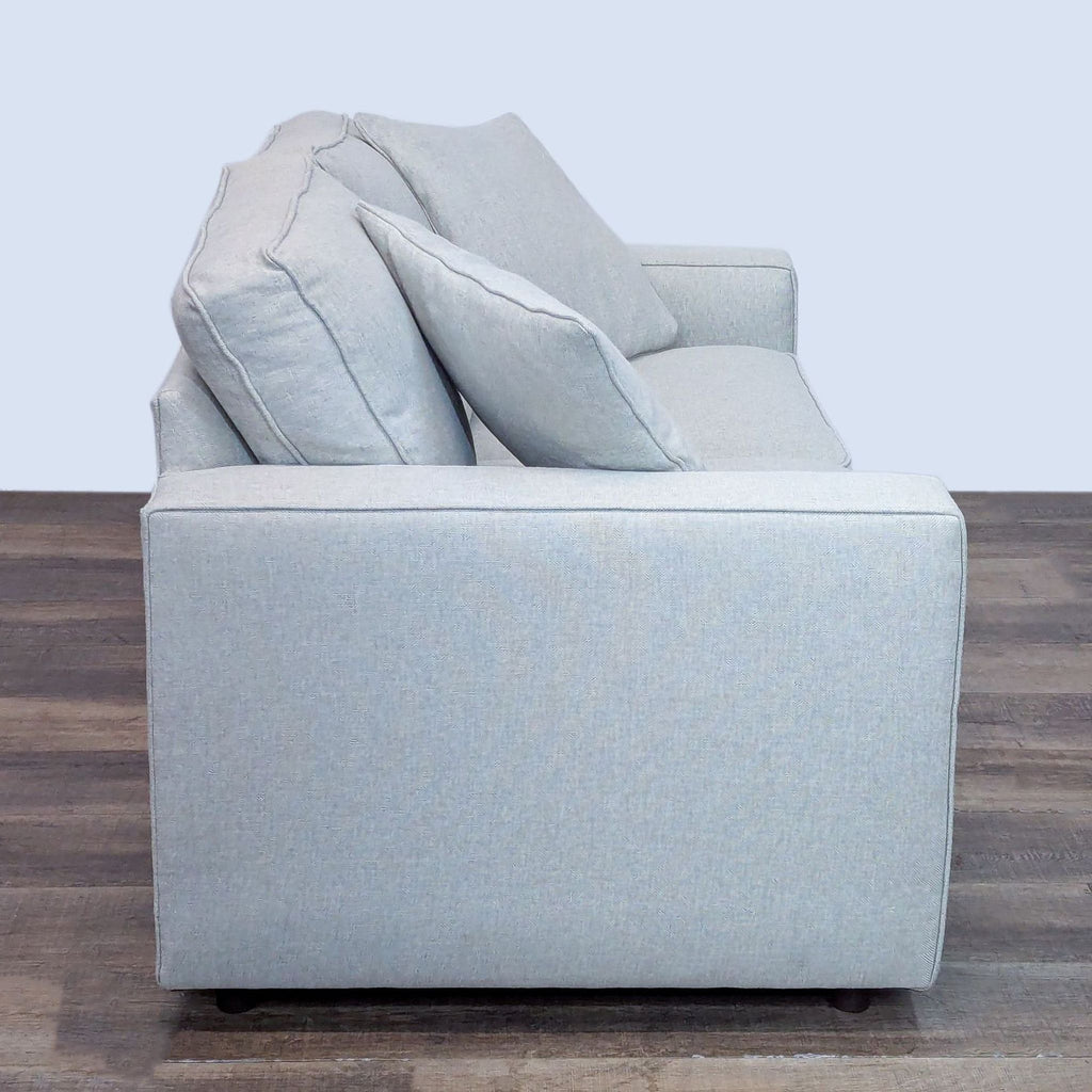 Side view of a Room and Board loveseat with soft cushions.