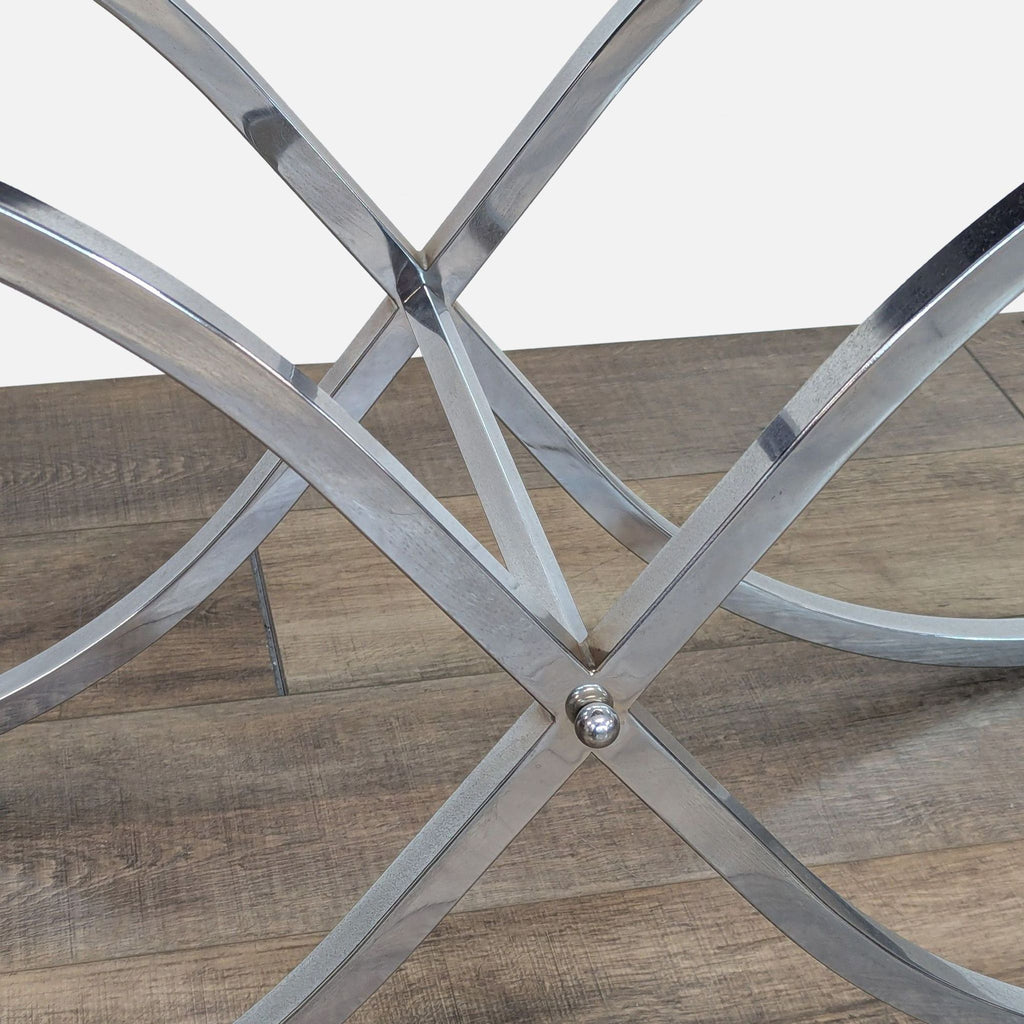 Close-up of the curved metal X-frame base of a console table.  