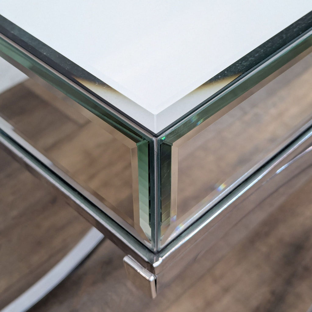 Corner detail of a beveled mirror table with metal frame.  