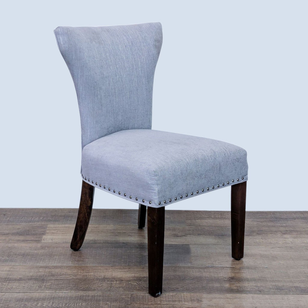 Elegant Reperch dining chair featuring nailhead trim and wooden legs.
