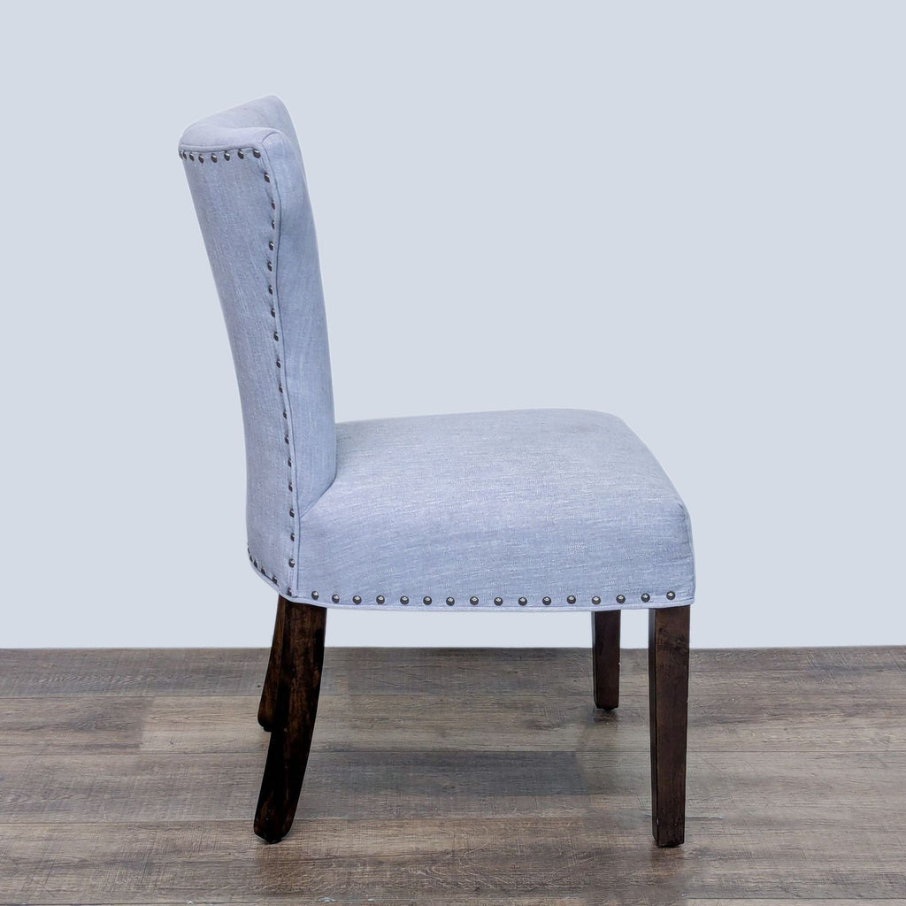 Side view of Reperch dining chair with a stylish tapered back and nailhead accents.