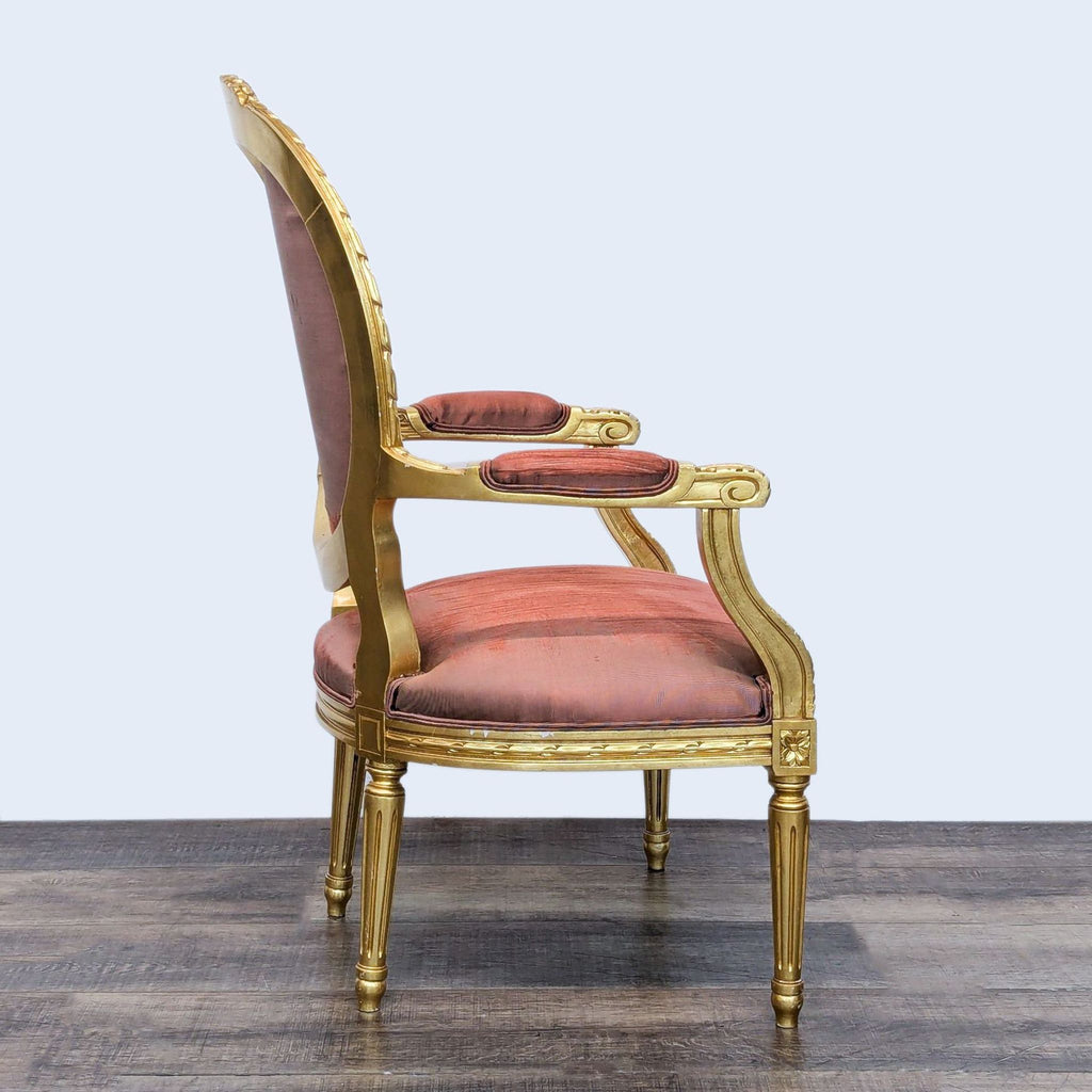 Side view of a French Provincial armchair in gold with a padded seat and back.