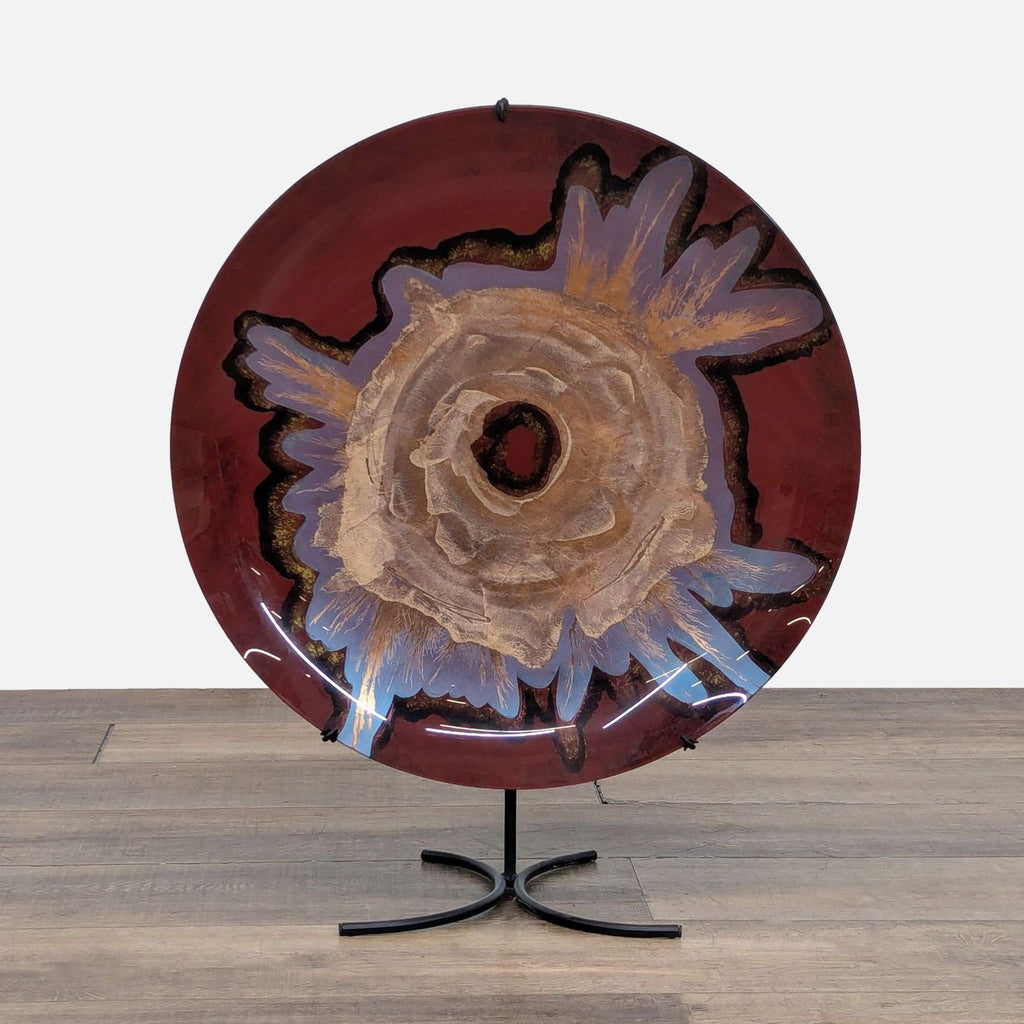 Decorative glazed plate on a stand with artistic floral design.
