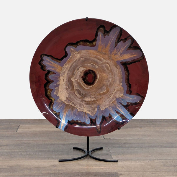 Decorative glazed plate on a stand with artistic floral design.