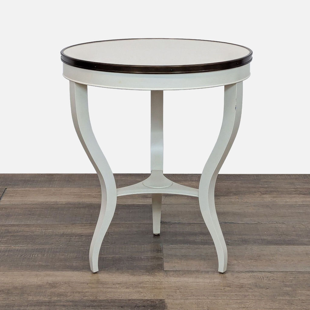Round side table with cream lacquer finish and serpentine legs.