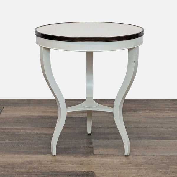 Round side table with cream lacquer finish and serpentine legs.