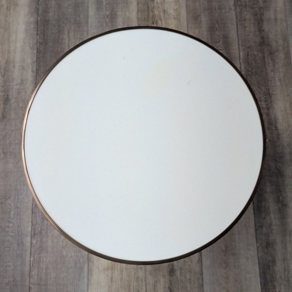 Top view of a round table with smooth cream surface and dark rim.