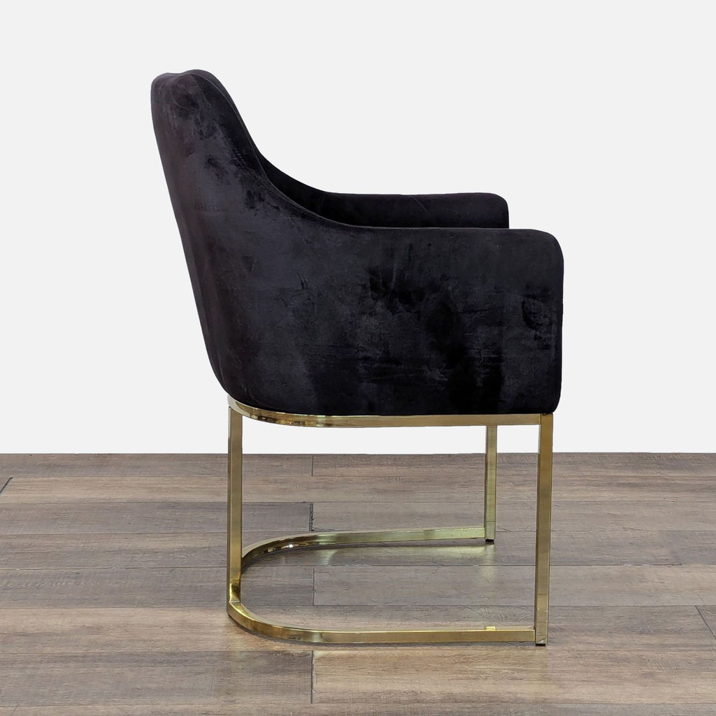 Side view of a black velvet lounge chair with an open gold metal frame.  