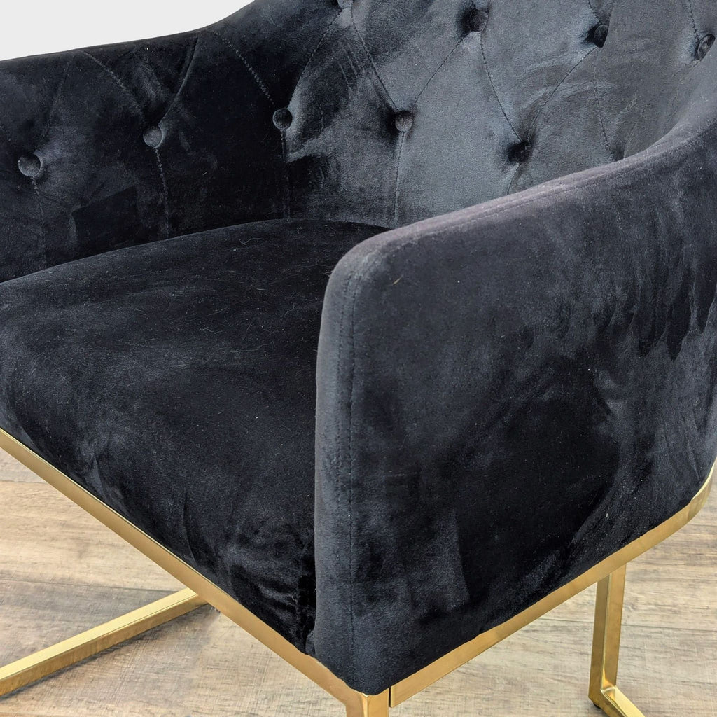 Close-up of tufted black velvet upholstery and gold frame on a lounge chair.